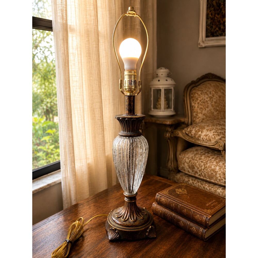 table lamp features a fluted,clear glass body with ornate bronze-finished metal
